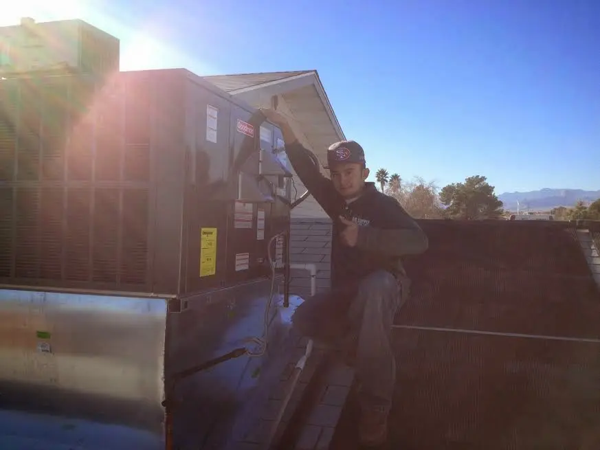 HVAC technician performing Boiler Repair on a rooftop unit in Watertown